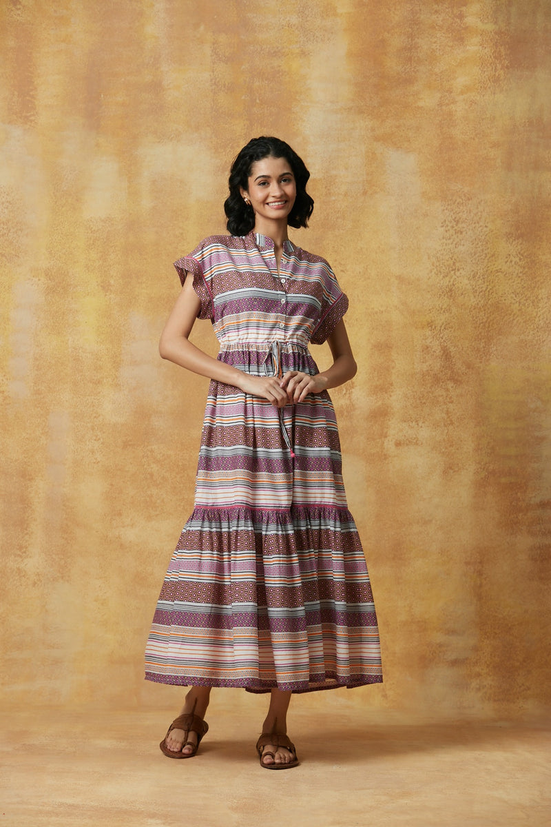 Woman wearing a striped dress against a textured beige background